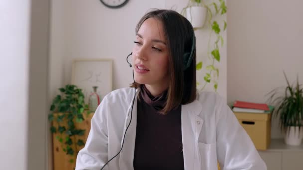 Portræt Ung Kvindelig Læge Headset Arbejder Høringslokalet Lytter Patienten Gennem – Stock-video