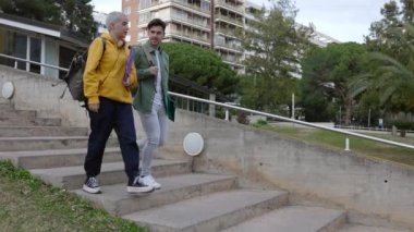 İki son moda üniversite öğrencisi dersten sonra binadan çıkıyorlar. Arkadaşlık ve eğitim kavramı.