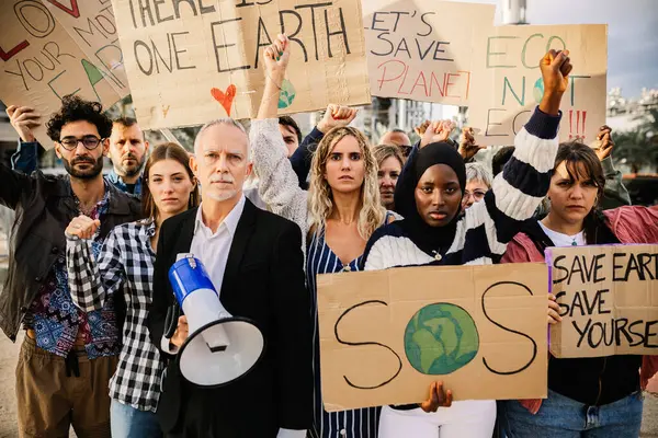 Diverse large group of activist people looking at camera holding banners for climate change. Environment and save the planet concept.
