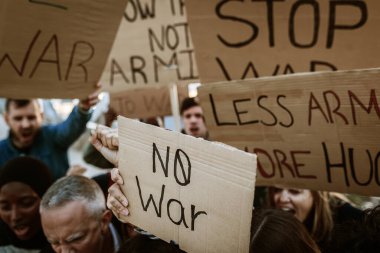 Dünya barışı için yürüyen bir grup aktivist. Çeşitli göstericiler savaş ve şiddeti protesto eden pankartlar ve posterler taşıyorlar. Savaş protestosu konsepti yok.