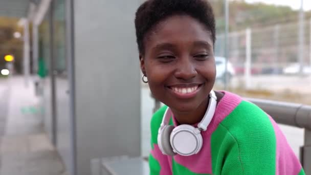 Jonge Afrikaanse Vrouw Met Een Draadloze Koptelefoon Die Tram Wacht — Stockvideo