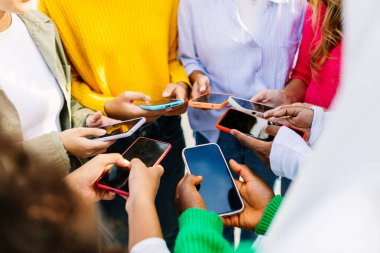 Şehir caddesinde birlikte cep telefonu kullanan tanınmayan bir grup insan. Çeşitli üniversite öğrenci arkadaşları cep telefonundan sosyal medya içeriğini izliyorlar. Cep telefonu bağımlıları konsepti.