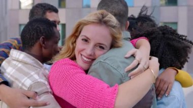 Şehir caddesinde birbirine sarılan genç bir arkadaş grubu. Güzel bir kadın kameraya gülümser ve çeşitli arkadaşlarla çoklu kucaklaşmanın tadını çıkarır. Aşk ve arkadaşlık kavramı.
