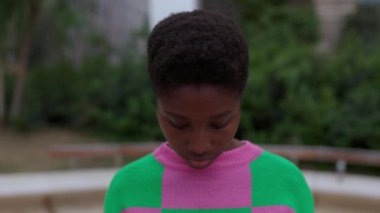 Genç Afrikalı bir kadının kameraya gülümseyişini gösteren yavaş çekim görüntüleri. Milenyum siyahi ve kısa saçlı bir kadının yakın plan portresi. Pozitif insanlar.