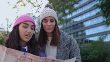 Kış tatilinde bir şehri ziyaret ederken harita okuyan iki turist kadın. Bayan arkadaşlar hafta sonu kaçamağının tadını çıkarıyorlar. Seyahat ve tatil konsepti.