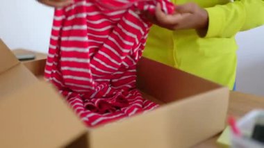 Ofis dükkanında genç Afrikalı bir kadının online alışveriş siparişi paketlediği yakın çekim görüntüsü. E-ticaret ve küçük işletme girişimcileri kavramı.