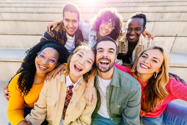 Portrait of multiracial young group of happy people laughing at camera together. Youth, community and friendship concept.