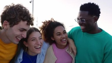 Farklı öğrenci arkadaşlardan oluşan neşeli bir grup dışarıda birlikte gülüyor. Çok ırklı gençler şehir sokaklarında eğleniyor, kaynaşıyorlar. Arkadaşlık ve gençlik kavramı.