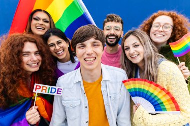 Dışarıda gay gururu günü kutlayan ve kameraya gülümseyen homoseksüel bir grubun portresi..