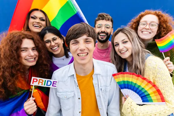 Dışarıda gay gururu günü kutlayan ve kameraya gülümseyen homoseksüel bir grubun portresi..