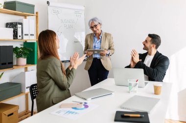 Çeşitli iş adamları bir toplantı odasında büyüme şirketinin amacını kutluyor. Takım çalışması ve başarılı profesyonel insan konsepti.