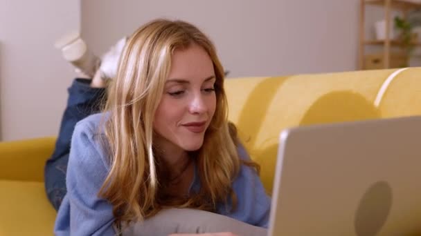 Щаслива Молода Красива Блондинка Використовуючи Ноутбук Лежить Дивані Квартирі Тисячолітній — стокове відео