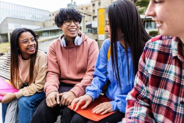 Üniversite kampüsünde tatilin tadını çıkaran bir grup çok ırklı öğrenci. Eğitim ve gençlik toplumu kavramı.