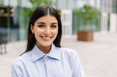 Şirket binasının önünde duran güçlü iş kadınının yakın plan portresi. Liderlik ve güçlendirme kavramı.