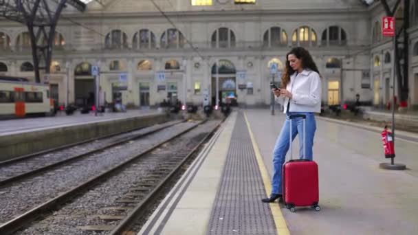 全长年轻的女旅行家与红色行李使用电话等候在火车站 旅行和假日生活方式概念 — 图库视频影像