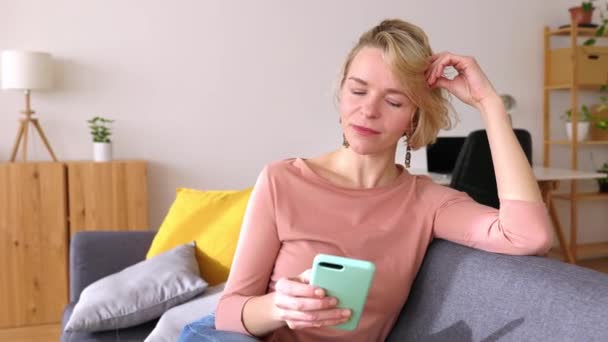 Mujer Adulta Media Que Relaja Sofá Usando Teléfono Móvil Feliz — Vídeos de Stock