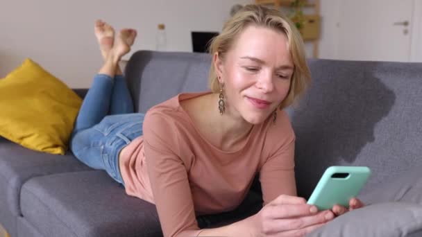 Femeie Adultă Mijlocie Care Relaxează Canapea Folosind Telefonul Mobil Acasă — Videoclip de stoc