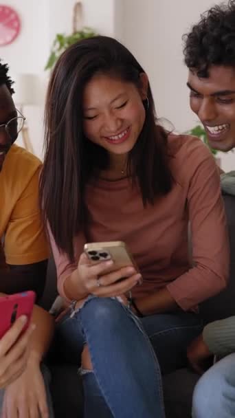 Grupo Joven Amigos Diversos Sentados Sofá Usando Teléfono Móvil Sonrientes — Vídeos de Stock