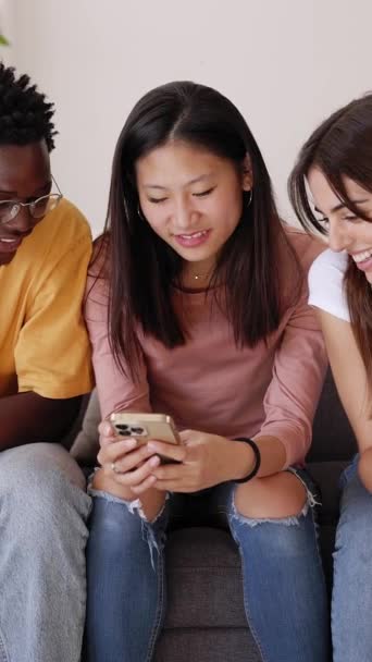 Trójka Nastoletnich Przyjaciół Bawiących Się Telefonem Komórkowym Siedzącym Kanapie Domu — Wideo stockowe