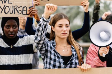 Çeşitli öğrenci protestocular fabrika önünde iklim değişikliğine karşı gösteri yapıyor. Küresel ısınma kavramı, aktivistlerin pankart tutması ve yumruk kaldırması.