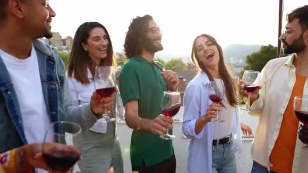 若い友人のグループは 屋上夏の夕日パーティーで一緒に踊っている間 赤ワインを味わうことを楽しんでいます スローモーション4K映像 — ストック動画