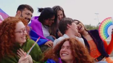 LGBT topluluğunun gençleri gey onur ayını dışarıda kutluyorlar. Gökkuşağı bayrağı taşıyan çeşitlilik LGBTQ grubu şehir caddesinde eğleniyor. 