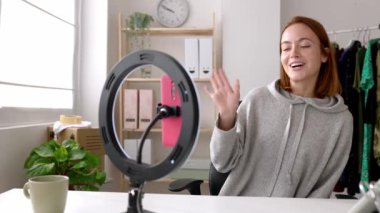 Sosyal medya için video kaydeden mutlu genç bir kadın. İçerik yaratan kadın evinde cep telefonuyla canlı yayında. Etkilenen insanlar ve eğilimler konsepti.