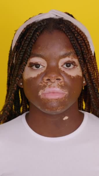 年轻的非洲少女的画像 带着白垩风望着摄像机 站在孤立的黄工作室背景上 积极向上的表情 灿烂的微笑 — 图库视频影像