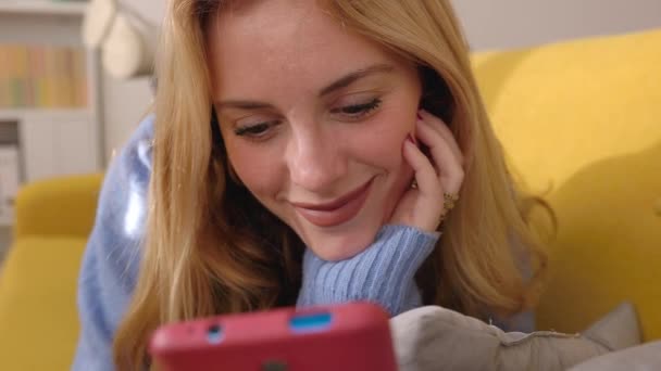 Ung Attraktiv Blond Kvinna Med Hjälp Mobiltelefon Enhet När Ligger — Stockvideo