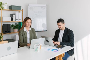 Çeşitli iş adamları modern bir ofisteki dizüstü bilgisayarla masa başında birlikte çalışıyorlar. Takım çalışması konsepti.