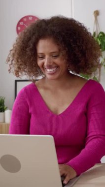 Yaratıcı iş kadını Afrikalı sahibi stüdyosunda dizüstü bilgisayar kullanıyor. Ev ofisinden online çalışan mutlu online girişimci kadın. Dikey HD video.
