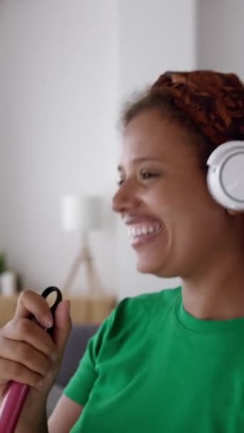 Szczęśliwa Młoda Afroamerykanka Bawiąca Się Śpiewem Podczas Sprzątania Domu Miotłą — Wideo stockowe