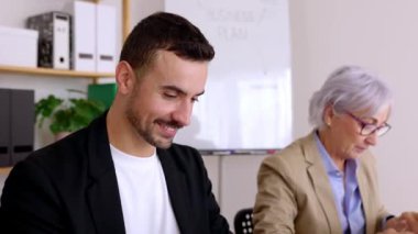 Ofisteki dizüstü bilgisayarda birlikte çalışan çeşitli iş adamları. Takım çalışması ve iş konsepti.