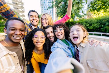Çok ırklı arkadaş grupları kentte birlikte vakit geçirip selfie çekiyorlar. Çeşitlilik ve gençlik toplumu kavramı.