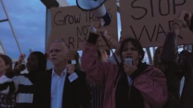 Dünyada savaş ve şiddeti protesto eden çeşitli aktivist grupları posterler ve pankartlar taşıyorlar..