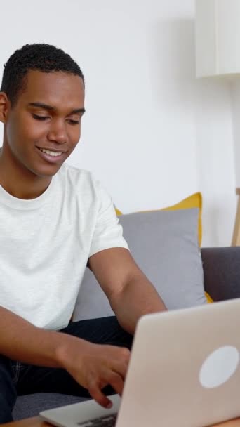 Szczęśliwy Młody Afrykanin Korzystający Laptopa Siedzącego Kanapie Mieszkaniu Koncepcja Technologii — Wideo stockowe