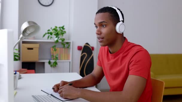 Щасливий Молодий Студент Навушниках Навчається Вдома Тисячолітній Чорний Чоловік Розмовляє — стокове відео