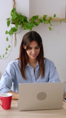 Heyecanlı genç bayan öğrenci ofis bilgisayarını kullanarak başarıyı veya başarıyı kutluyor. Dikey HD video.