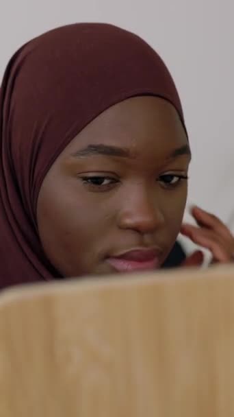 若いアフリカの黒人の十代の少女は イスラム教徒のヘッドスカーフを自宅に置いている間に鏡を見ています 垂直Hd ビデオ — ストック動画
