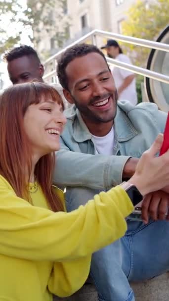 Szczęśliwi Młodzi Ludzie Korzystający Telefonu Komórkowego Siedzącego Zewnątrz Wieloetniczna Grupa — Wideo stockowe