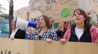 Küresel iklim değişikliği grevinde pankartlı ve posterli çeşitli insanlar grubu.