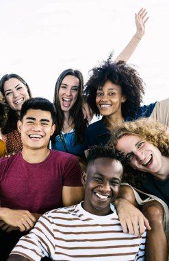 Şehir merdivenlerinde oturan çeşitli üniversite arkadaşlarının dikey portresi. Sokaklarda eğlenen ve dinlenen çok ırklı gençler. Arkadaşlık, gençlik ve üniversite konseptine dönüş.