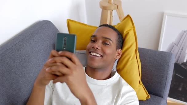 Молодий Дорослий Чоловік Використовує Мобільний Телефон Дивані Щасливий Тисячолітній Чоловічий — стокове відео