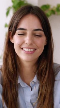 İş yerinden laptopla yapılan görüntülü konuşmayı dinleyen mutlu, genç bir bayanı kapatın. Genç girişimci bayan partnerle çevrimiçi görüşme yoluyla konuşuyor. Dikey HD ekran videosu.