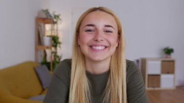 Dizüstü bilgisayardan video dinleyen güzel, genç bir kadın. Web kamerasında, sanal toplantı konferansına katılan gülümseyen bir kadının portresi. E-öğrenim ve iş konsepti.