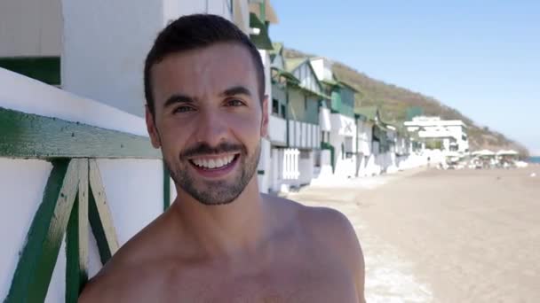 Retrato Jovem Homem Feliz Praia Sorrindo Para Câmera Sobre Casas — Vídeo de Stock