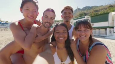 Bir grup çok ırklı mutlu genç arkadaş birlikte online video görüşmesi yapıyorlar. Yaz tatilinin tadını çıkarıyorlar.