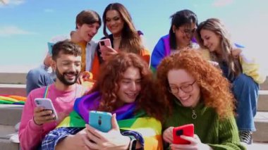 Farklı genç LGBT dostları açık havada birlikte akıllı telefon kullanıyor. İletişim ve LGBTİ topluluk kavramı.