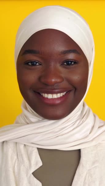 노란색 스튜디오 배경에 카메라에 무슬림 머리카락에 아프리카 여자의 초상화 행복과 — 비디오