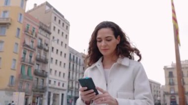Şehirde telefon kullanan genç bir kadın. Şehir caddesinde yürürken hücrede sohbet eden mutlu bin yıllık kadınlar.